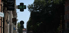 A local resident walks past a pharmacy sign displaying the temperature of 42,5°C in Toulouse, southern France, on July 17, 2022, as a heatwave hits France. - Fifteen departments, mostly on the western side of France, are placed under "red vigilance" as a heat wave hits the country and should reach its peak on July 18, 2022, announced on July 17, 2022 Meteo France. (Photo by Valentine CHAPUIS / AFP)