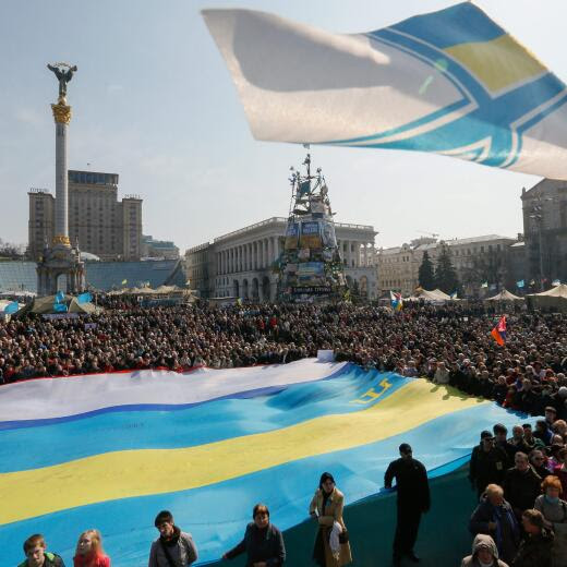 epaselect epa04137395 Ukrainians hold a giant flag made of national, Crimean Tatars and Crimean flags during a rally on Independence Square in Kiev, Ukraine, 23 March 2014. Russia officially declared Crimea part of its zone of military control on 22 March, even as isolated military units loyal to Ukraine hung on grimly at a few sites in the contested peninsula. EPA/SERGEY DOLZHENKO