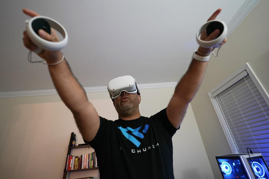 Pastor D.J. Soto, the lead pastor of VR Church, delivers a sermon in his home Sunday Jan. 23, 2022, in Fredericksburg, Va. Soto sings, preaches and performs digital baptisms in the metaverse to a growing congregation of avatars.