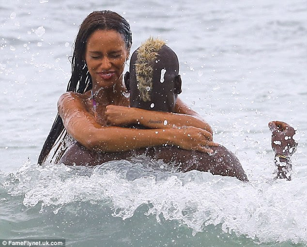 Anywhere but the face: But the brunette beauty didn't look quite as pleased when a wave came crashing towards her