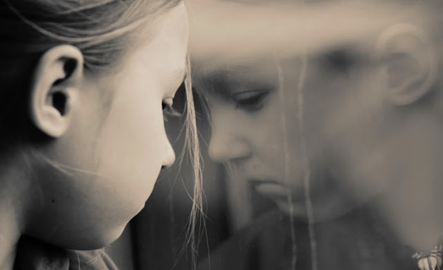 Little girl looking into window