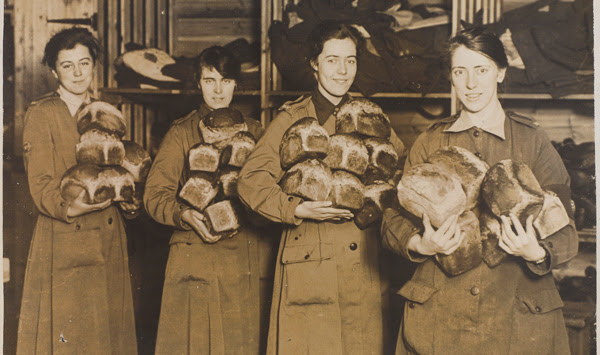 Members of the QMAAC holding bread