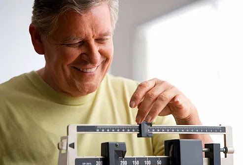 Mature man moving slider on medical scale