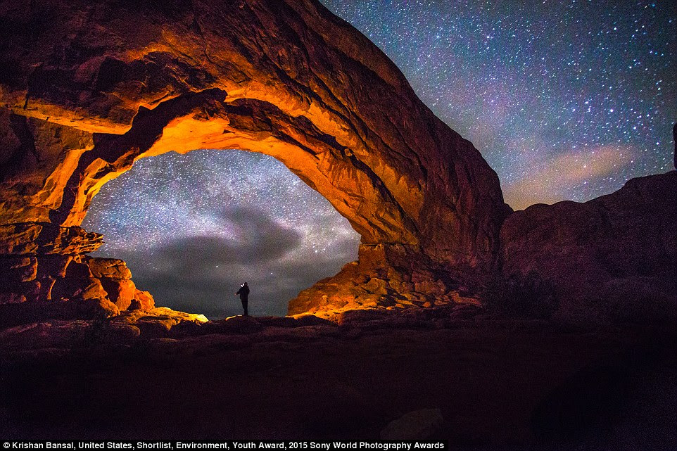 Youth entrant Krishnan Bansal wrote: 'Just me, observing the stars above ancient sandstone landscape of Arches National Park. It's amazing how when we view our earthly environment in its natural state, the more alien it becomes. Single exposure, no composites'