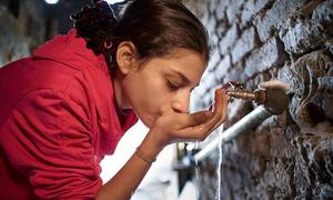 Una niña bebe agua de una toma en su casa en un barrio marginal de El Cairo, Egipto.