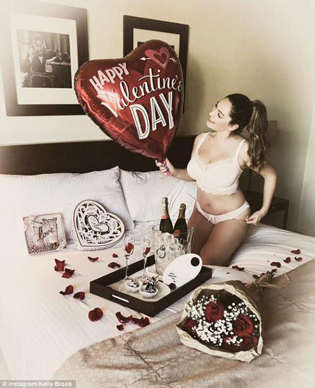 Lucky lady: An underwear clad Kelly looked as though she had been spoiled rotten as she was surrounded by Valentine's day themed treats on a lavish bed