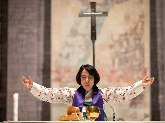 The Rev. EunKyung Kim of the Presbyterian Church in the Republic of Korea blesses communion elements during September 2022 prayer for peace and reunification between South and North Korea, WCC's 11th Assembly held in Karlsruhe, Germany.