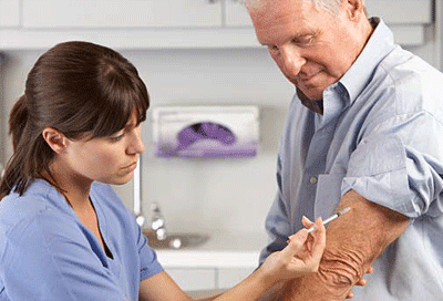 Nurse administering flu shot to a senior. 