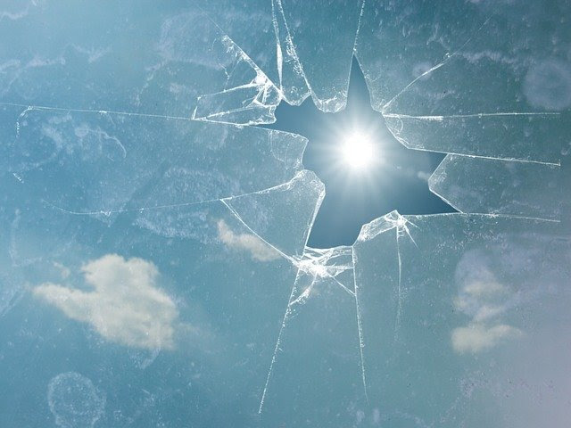 Broken Window with sun piercing through the cracks