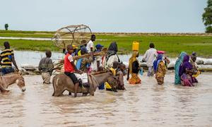 Los habitantes de Rann, en el noreste de Nigeria, vadean la carretera principal inundada, a la que ahora no se puede acceder en vehículo.