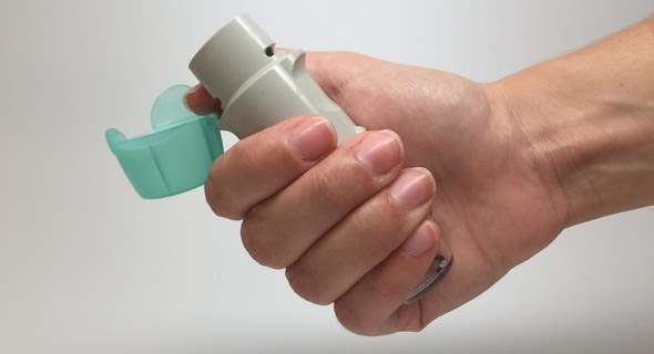 Hand holding an asthma inhaler