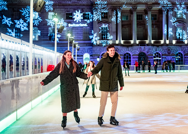A couple hold hands while skating on the ice at Somerset House.