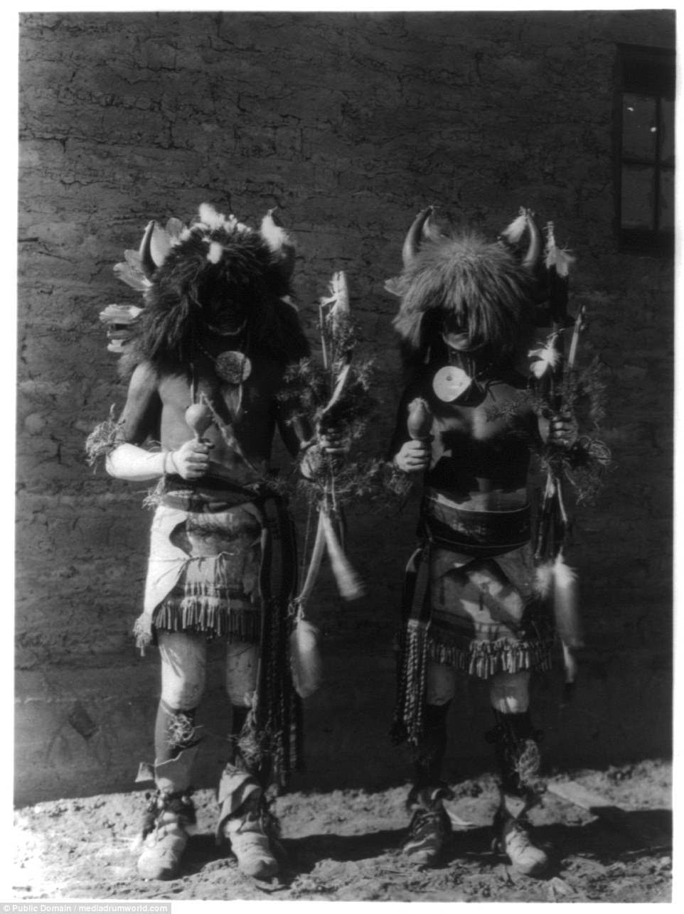 Two Native American men in costumes wearing horns of buffaloes pictured in 1907 