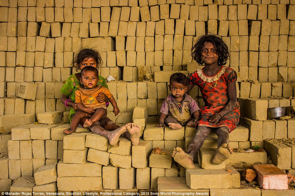 Brick Makers: Children resting after breakfast in Nabadwip, West Bengal. 'Every day of the year preparing for the rain season, groups of families gather to make bricks at large factories in remote villages all over India,' said Venezuelan photographer Mahadev Rojas Torres