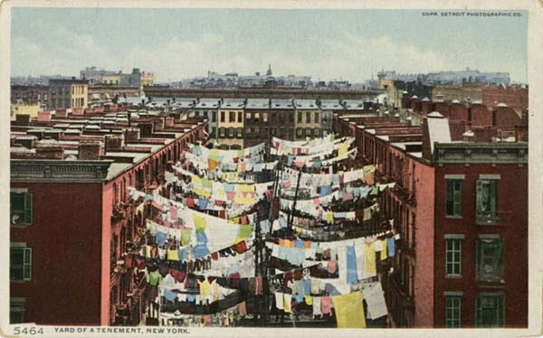 Laundry hangs between rows of tenements.