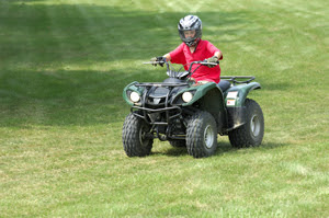 Boy with a helmet riding an ATV
