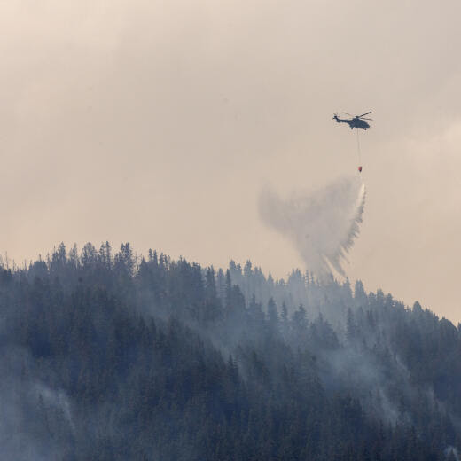 A Swiss Air Force Super Puma helicopter drops water on a wildfire on the flank of a mountain in Bitsch near Brig, Switzerland, July 18, 2023. REUTERS/Denis Balibouse