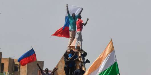 Protesters wave Nigerien and Russian flags as they gather during a rally in support of Niger's junta in Niamey on July 30, 2023. Thousands of people demonstrated in front of the French embassy in Niamey on Sunday, before being dispersed by tear gas, during a rally in support of the military putschists who overthrew the elected president Mohamed Bazoum in Niger. Before the tear-gas canisters were fired, a few soldiers stood in front of the embassy to calm the demonstrators. (Photo by AFP)