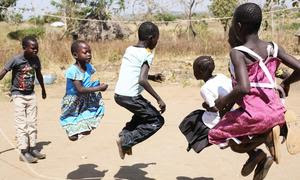 Niños refugiados saltan la cuerda en el asentamiento de Palabek Ogili, en Sudán del Sur.