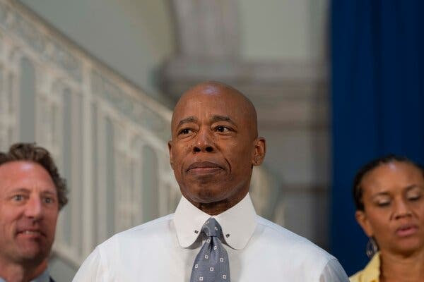 Mayor Eric Adams stands at a news briefing in City Hall.