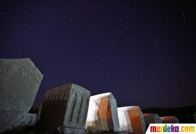 Bintang Jatuh atau meteor terlihat di langit malam kompleks kuburan 