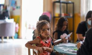 Una niña venezolana posa para la cámara en el centro de acogida para familias migrantes situado en Iquique, Chile. 