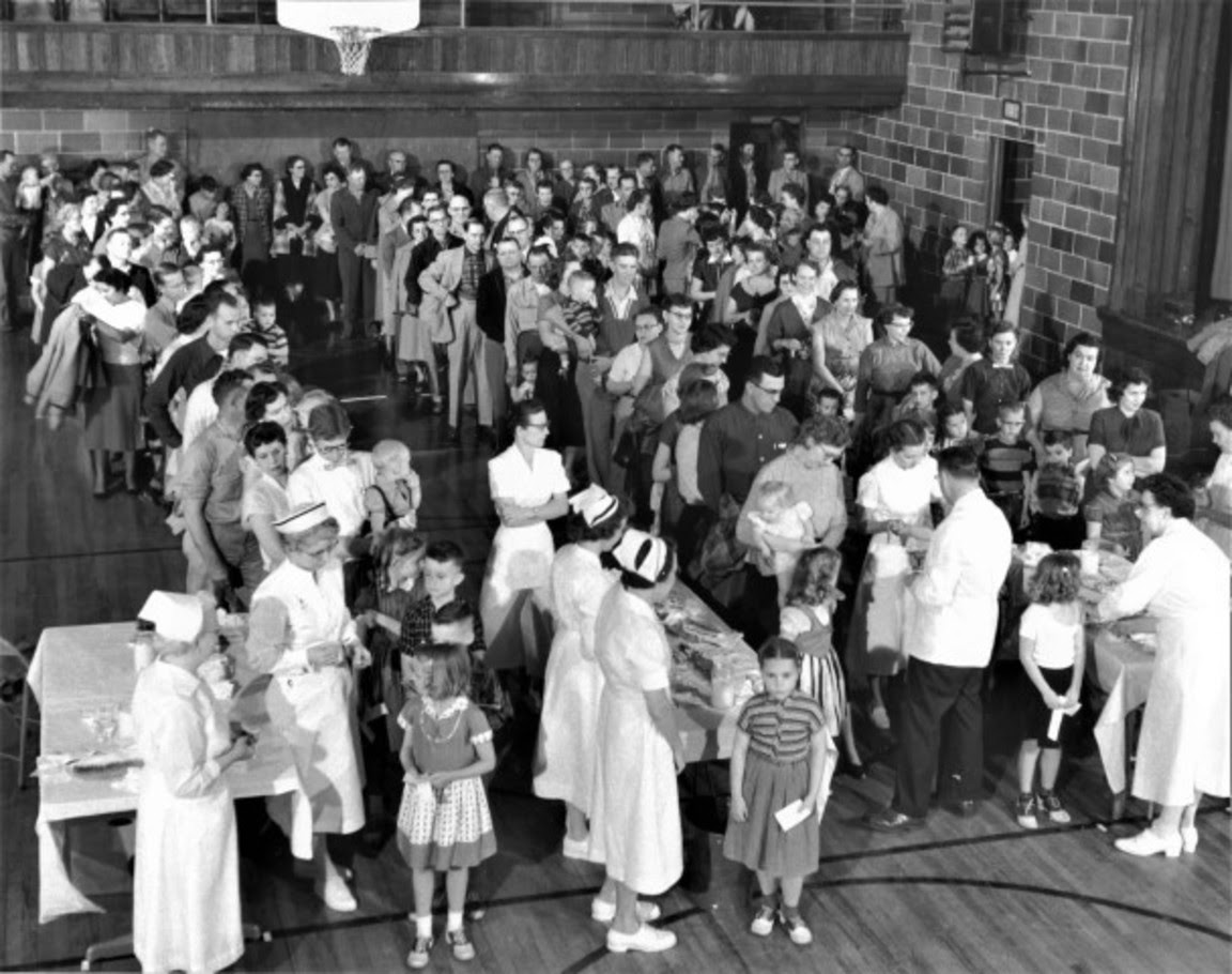 Black and white photo of residents of Protection, Kansas, gathered in the high school gym in April 1957 to receive the polio vaccine. The small southwest Kansas town was the first in the nation to be fully inoculated against the disease.