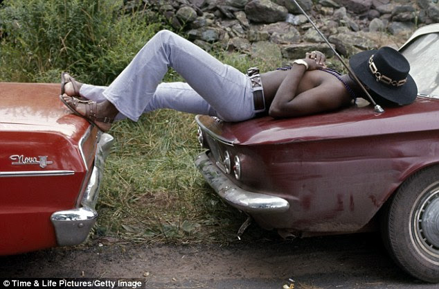 Living arrangements: Concert-goer sleeping on two cars at Woodstock in Bethel, New York, on August 1, 1969