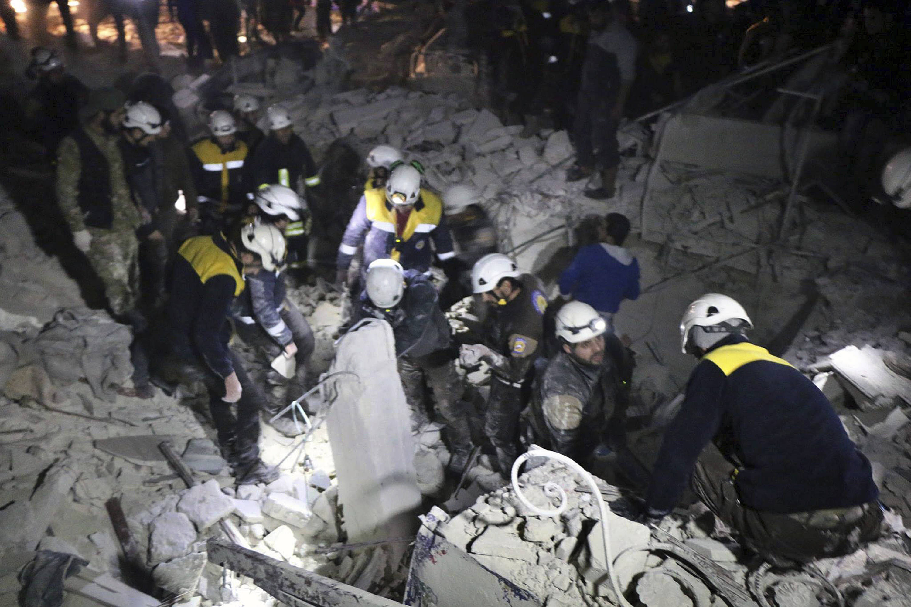 Members of the White Helmets, a civilian rescue team, inspect a damaged building after a bombing in Idlib, Syria, on Jan. 7, 2018. (Syrian Civil Defense White Helmets/AP)