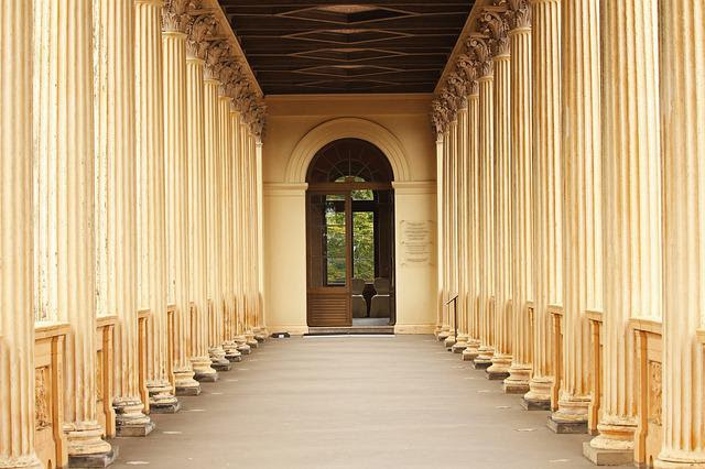 Long hallway to arched doorway.