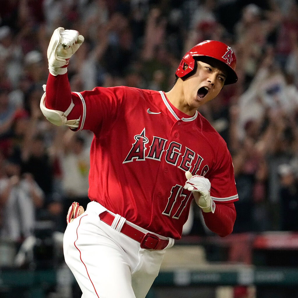 Shohei Ohtani, wearing an Angels uniform, pumps his fist in celebration.