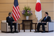 Secretary Blinken is sitting next to Japanese Prime Minister Kishida. Flags of the United States and Japan in the background. 