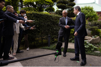 Secretary Blinken is shaking hands with U.S. Ambassador to Japan Rahm Emanuel. There is press in front of them.  