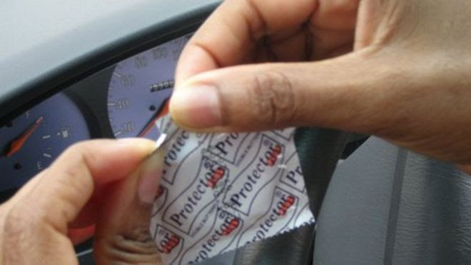 A Zimbabwean woman opens a condom packet in a car