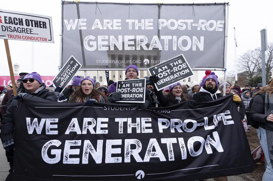 nti-abortion activists march outside of the U.S. Supreme Court during the March for Life in Washington. They are holding a banner that says "We are the pro-life generation." There is also a sign behind them that says "We are the post-Roe generation."
