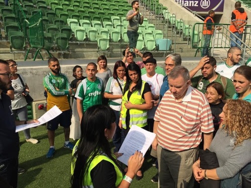 Grupo de cegos fazendo o reconhecimento tátil do campo. Bruno e Rosa a frente com papéis nas mãos.