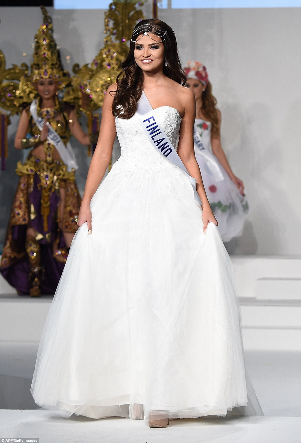 Miss FinlandSaara Ahlberg looked like she was expecting a groom to be at the end of the catwalk as she appeared in this wedding dress style gown and wearing a diamante tiara