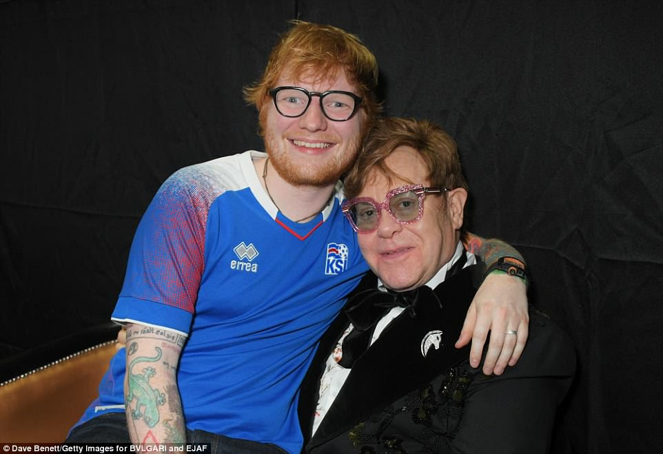 Pals: Ed wrapped his arm around Elton while they caught up backstageÂ 