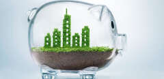 Sustainable urban development concept with grass growing in shape of a city inside transparent piggy bank