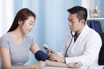 Doctor taking patient's blood pressure