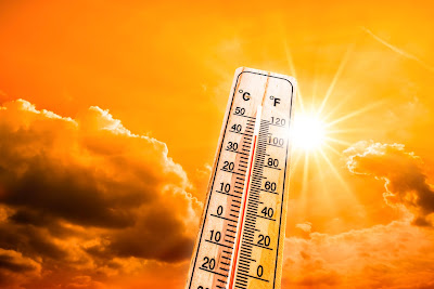 A thermometer reaches 100 degrees Fahrenheit in front of a sunny orange background.