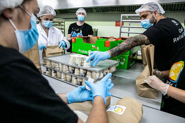 Volunteers prepare food packages for people in need in Barcelona, Spain