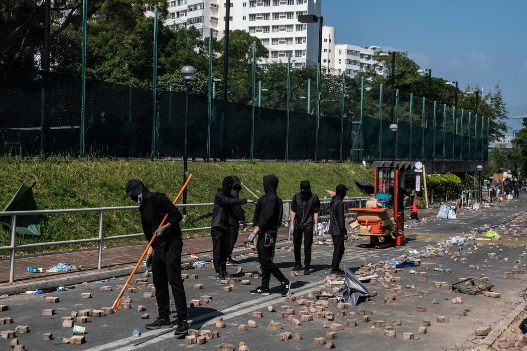 在香港中文大學，抗議者在一條滿是磚塊垃圾的馬路上。本週，警方向一所大學的校園發射催淚瓦斯，打破了人們關於教育機構不可侵犯的概念。