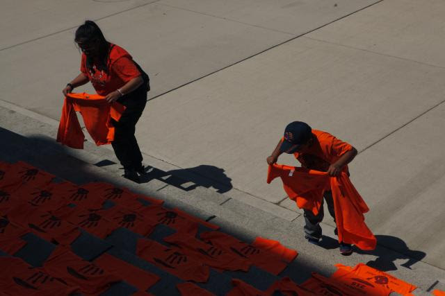 Photo showing orange shirts being placed outside the legislature in Victoria, B.C. in honour of 215 children buried in an unmarked grave at the Kamloops Residential School.
