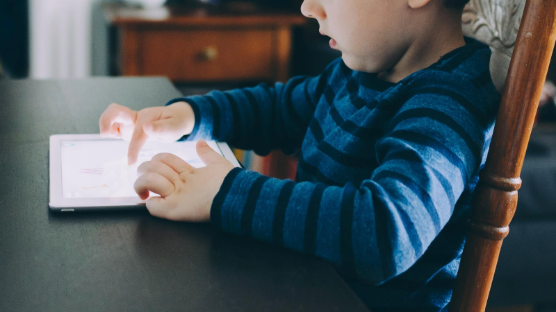 Child interacting with tablet