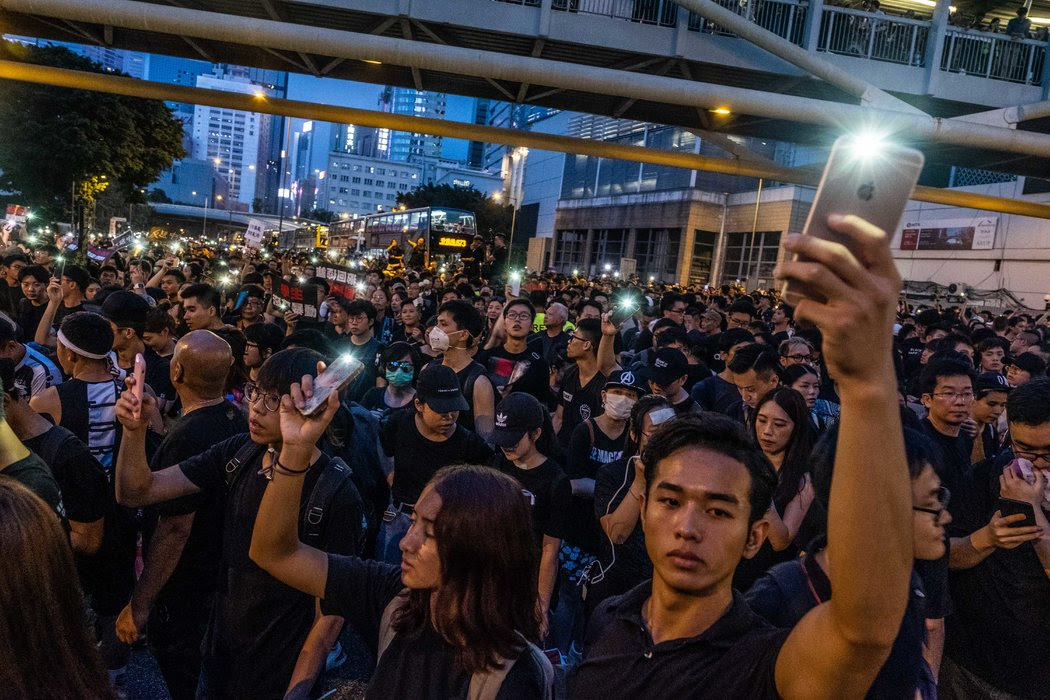 去年在香港，人們打開了智能手機電筒，紀念一名死去的抗議者。