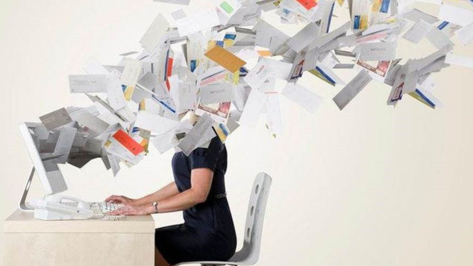 Person typing on the computer with papers flying at her head