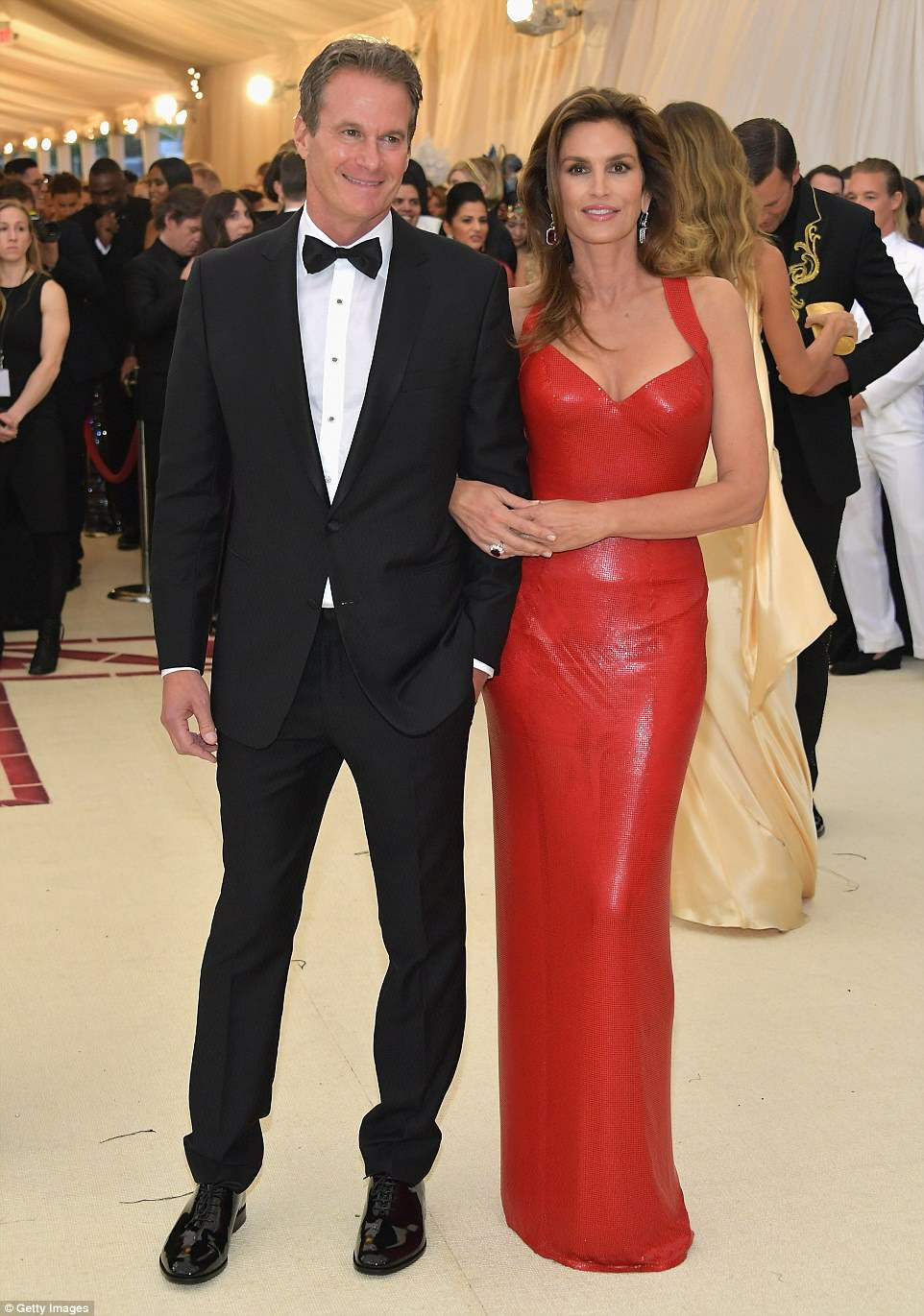 Supermodelo: Cindy Crawford escolheu um vestido vermelho justo;  posando com o marido Rande Gerber