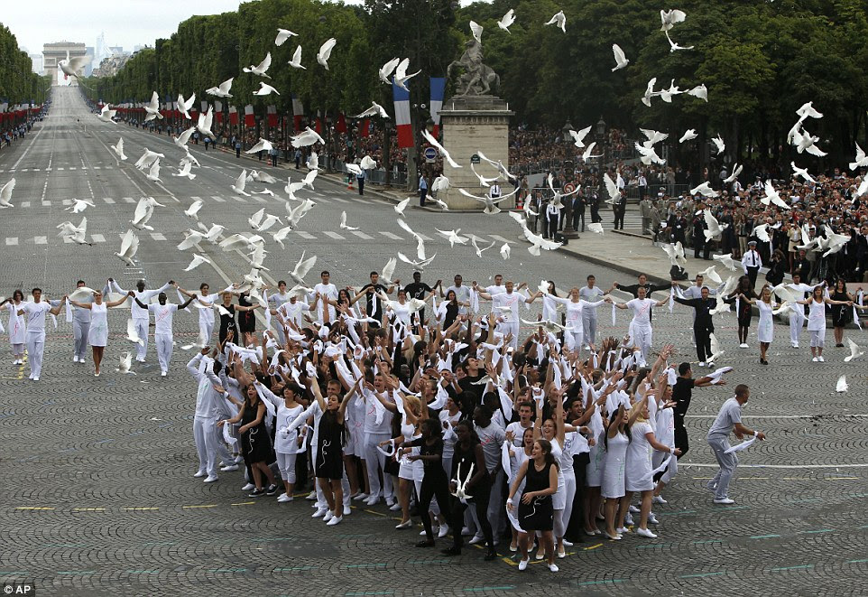 A group of young people released doves as the international sign of peace following the military parade through the centre of Paris to celebrate Bastille Day