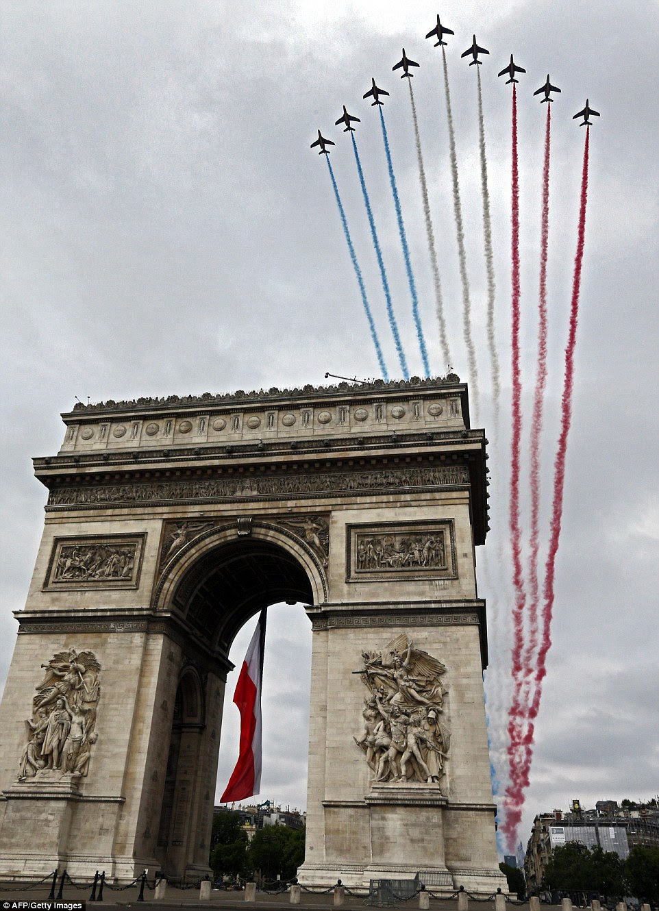 The Alpha jets of the French Air Force wow the crowds as they maintain a tight formation above the Arc de Triomphe